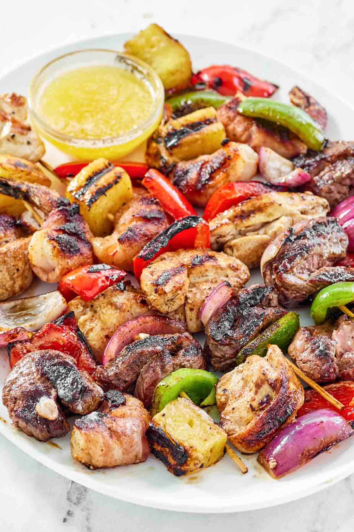 Chicken, steak, bacon-wrapped shrimp, veggie, and pineapple fajita skewers.