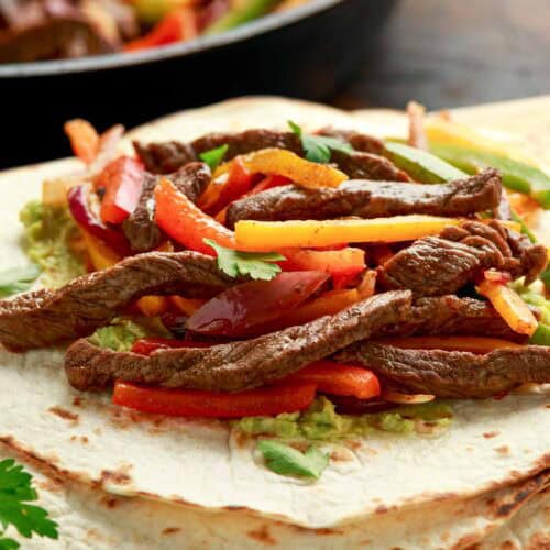 Steak fajitas on top of tortillas.