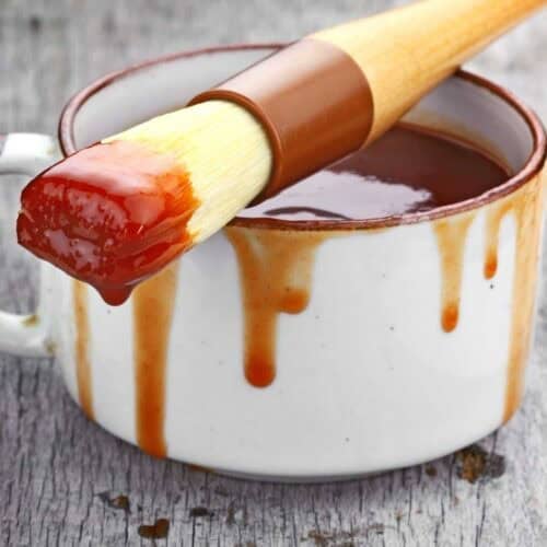 BBQ sauce in a cup and on a basting brush.