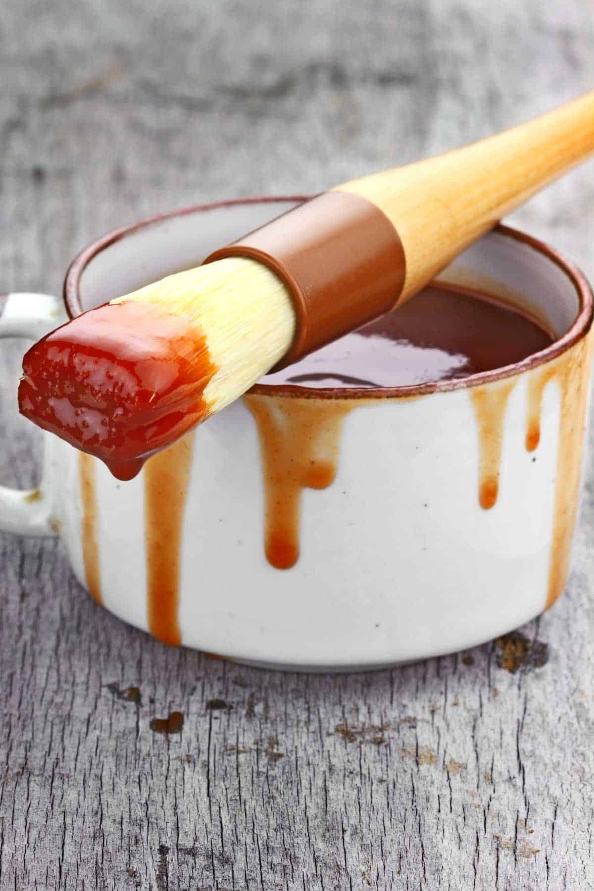 BBQ sauce in a cup and on a basting brush.