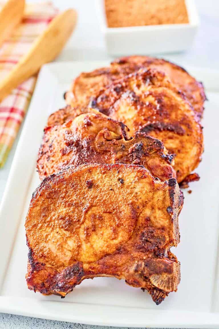 A platter of seasoned and cooked bone-in pork chops.
