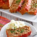 Copycat Boston Market meatloaf on a platter and a slice with mashed potatoes on a plate.