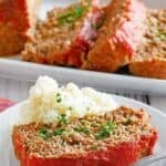 Copycat Boston Market meatloaf slice, mashed potatoes, and a fork on a plate.