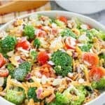 Homemade fresh broccoli salad loaded with bacon, cheese, onion, tomatoes, almonds, and dressing.