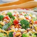Fresh broccoli salad loaded with bacon, cheese, onion, tomatoes, almonds, and dressing.