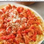 Copycat Olive Garden sausage and peppers rustica pasta topped with shredded mozzarella.