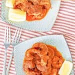 Copycat Red Lobster Cajun shrimp and lemon wedges on two plates.