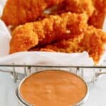 Copycat Red Robin campfire sauce in a condiment cup served with fried chicken tenders.