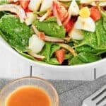 Spinach salad and hot bacon dressing in bowls.