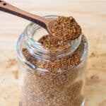 Homemade taco seasoning in a glass spice and on a spoon over it.