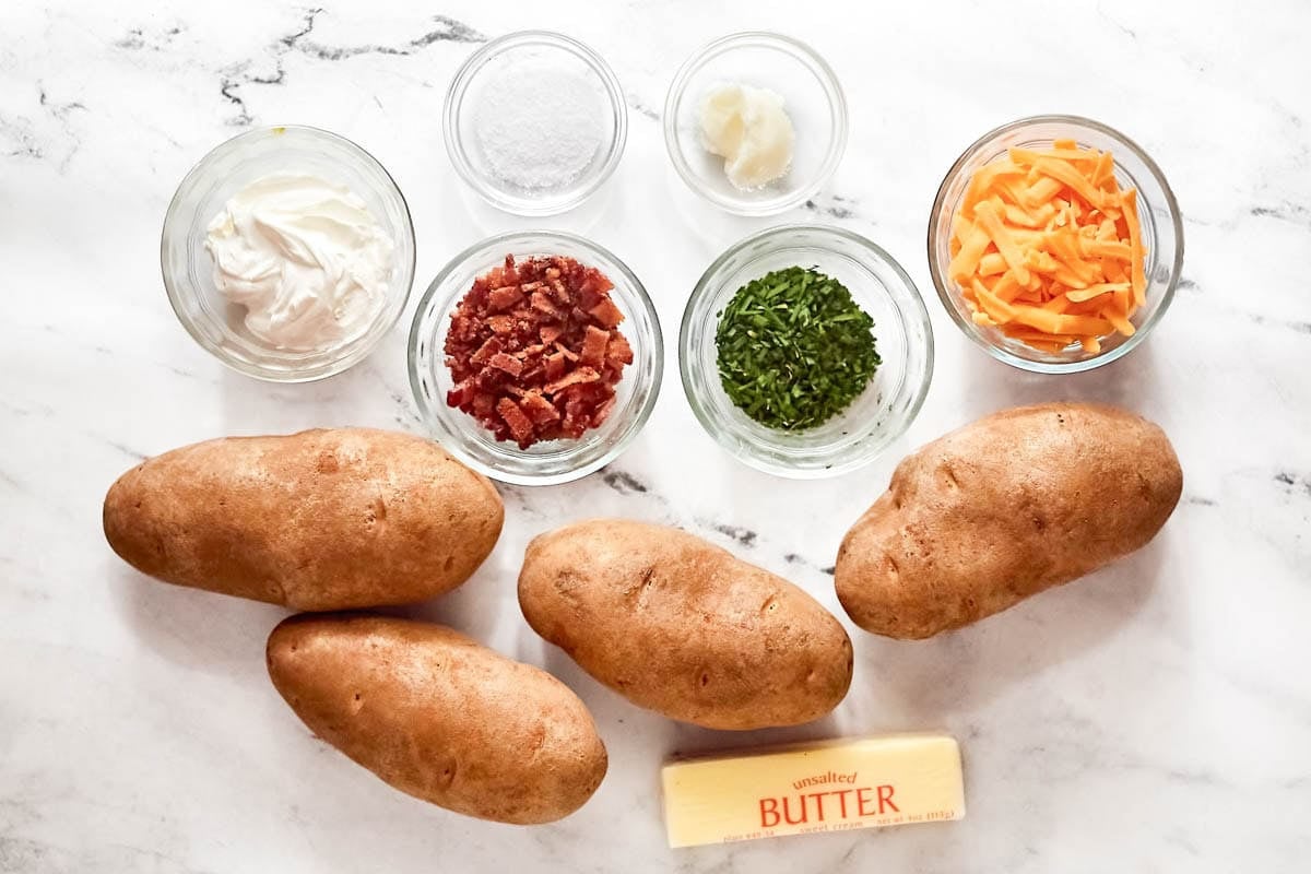 Russet potatoes, butter, bacon bits, shredded cheese, sour cream chives, and salt.