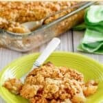 Old-fashioned apple crisp with oat crumb topping on a plate and in a baking dish.