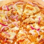 Copycat California Pizza Kitchen BBQ chicken pizza on a wooden pizza peel.