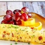 Copycat IHOP bacon temptation omelette, grapes, and orange slices.