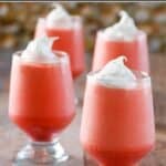 Homemade Jell-O 1-2-3 layered dessert in four glasses and spoons by them.