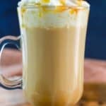 Copycat Starbucks caramel macchiato topped with whipped cream and caramel sauce in a glass mug.