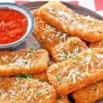 Copycat TGI Friday's crispy fried mozzarella sticks served with marinara sauce.