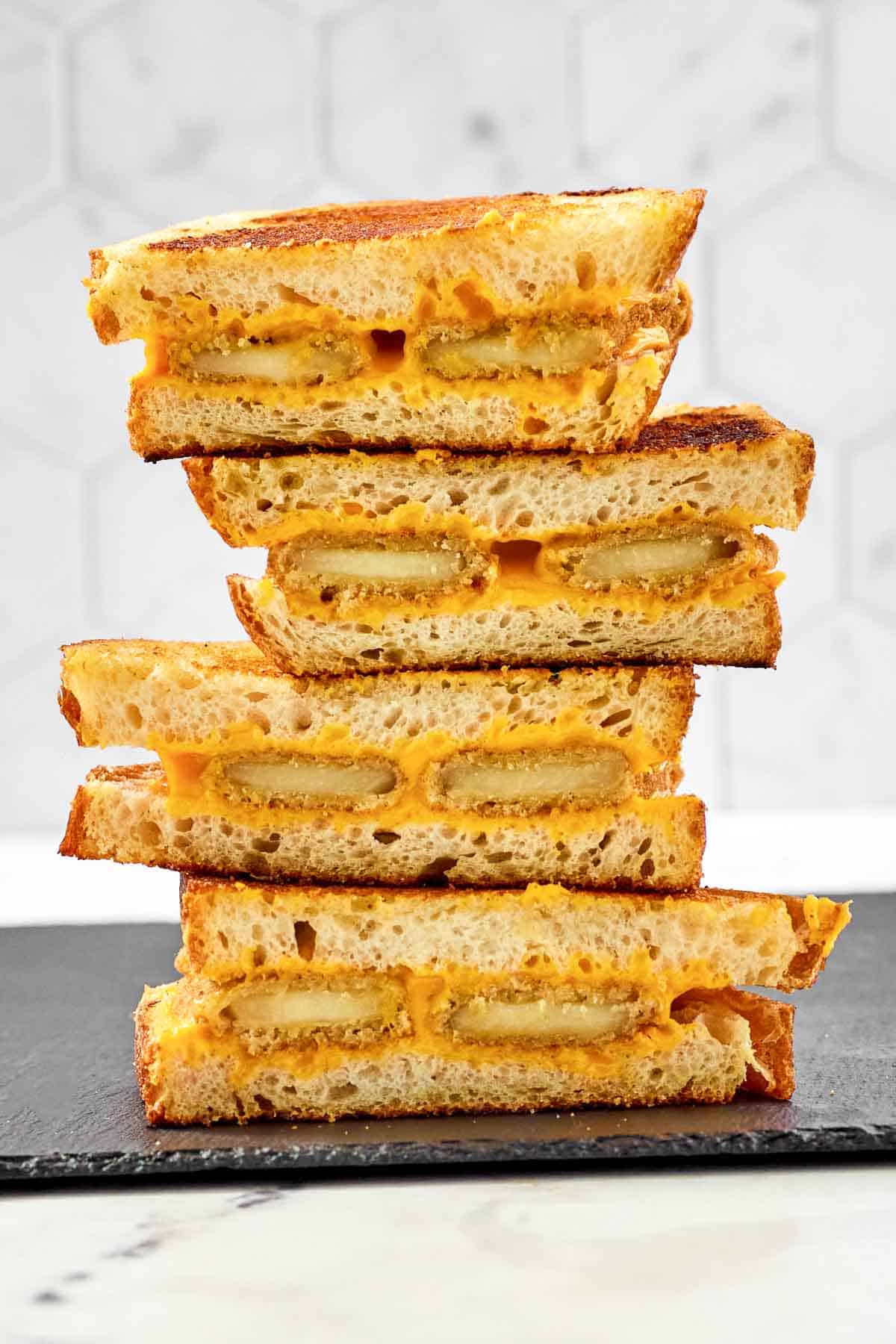 Slices of fried cheese grilled cheese sandwiches in a stack.